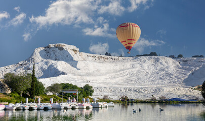 Denizli, Turkey, May 1, 2023: Hot air balloons and Natural travertine pools at sunrise in...