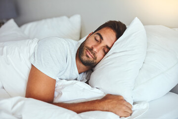 Man, sleeping and bed in morning rest for healthy wellness, peace and quiet on comfort pillow at home. Tired or exhausted male person asleep or dreaming on peaceful holiday or weekend in the bedroom - Powered by Adobe