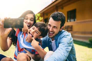 Happy family, smile and silly face for selfie, funny photo or profile picture in social media vlog outside home. Mother, father and child smiling with goofy facial expression for fun memory together