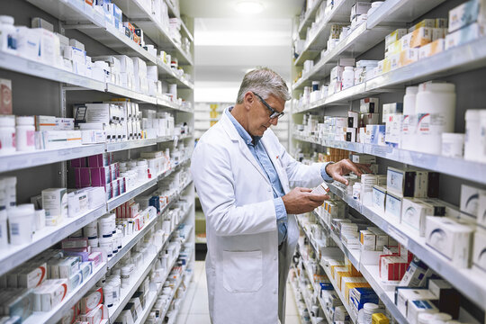 Pharmacy, medicine and search with man at shelf in drug store for thinking, inspection and inventory. Medical, healthcare and pills with senior male pharmacist for expert, wellness and product