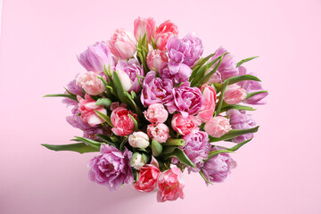 Fototapeta na wymiar Beautiful bouquet of colorful tulip flowers on pink background, top view