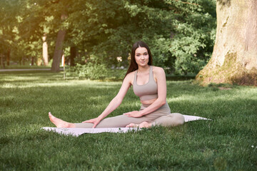 Sports woman doing yoga exercise and relax with sportswear in green park at summer, healthy lifestyle concept