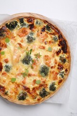 Delicious homemade quiche with salmon and broccoli on white table, top view