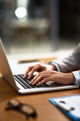 Laptop, email and hands of a person at a desk for work, internet and connection at night. Business, corporate and a secretary or receptionist typing on a computer for late admin online in an office