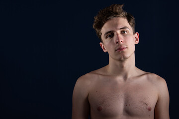 Fototapeta premium Young attractive man with athletic body posing in the studio.