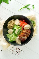 Quinoa with chicken and salad on a black plate. Bowl superfood