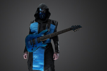 Shot of Ice ninja with scar and electric guitar dressed in mask and hood.
