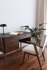 Workroom with vintage desk and chair and philodendron behind