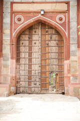 Small open door inside a large wood door Arab Ki Sarai gateway  India