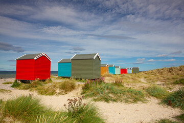 Fototapeta na wymiar Colorful wooden beach huts at Findhorn beach, Moray coast, Scotl
