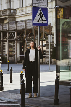 The white beatiful girl stands behind road sign