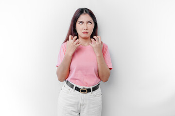 A dissatisfied young Asian woman looks at the camera posing on a white background, disgruntled girl with irritated face expressions show negative attitude concept image