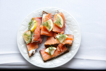 A top down view of a catered platter of smoked salmon crostinis.