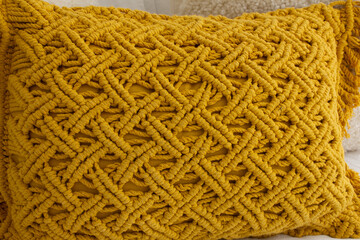A closeup view of the texture of a yellow throw pillow.
