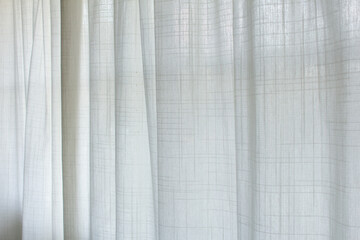 A view of a sheer white curtain diffusing the exterior sunlight, as a background.