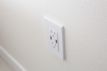 A view of a modern design electrical plug socket in a home setting.
