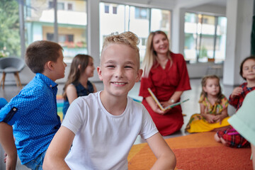 Reading time in an elementary school or kindergarten, a teacher reading a book to children in an elementary school or kindergarten. The concept of pre-school education. Selective focus