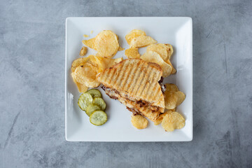 A top down view of a panini press beef and cheese melt sandwich.