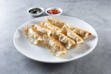 A view of a plate of Chinese potstickers.