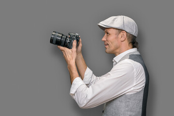 Man with professional photo camera having photography workshop on gray background