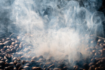 Coffee beans roasting with smoke,  selective focus, and soft focus.