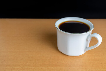 close up black coffee with white mug on wooden desk