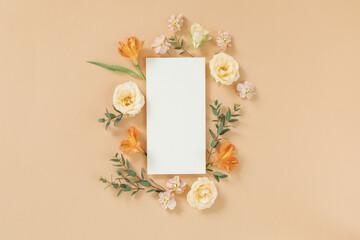 Blank paper card, floral arrangement on beige background. An aesthetic artistic template for a...