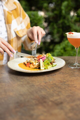 Female hands are eating seafood salad, hands are only visible, restaurant served table