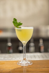 yellow cocktail with mint on the bar