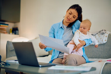 Obraz premium Multitasking mother with baby working at home.