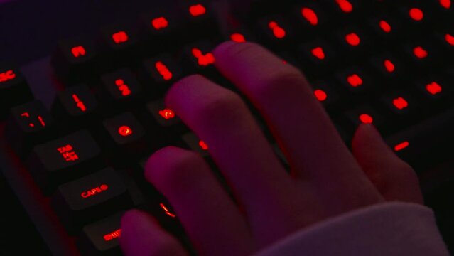 Gamer playing on gaming Keyboard with RGB lights