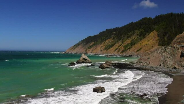 Aerial cinematic drone California coastline Highway 1 Montana Pacifica Gray Whale Cove State Beach Big Sur black sand aqua deep blue water windy surf epic roadtrip forward zoom in movement