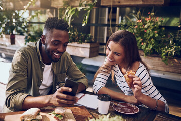 Restaurant, happy and black man and woman with phone for social media, internet and online website. Coffee shop, communication and friends on smartphone laugh at meme, talking and chat at breakfast