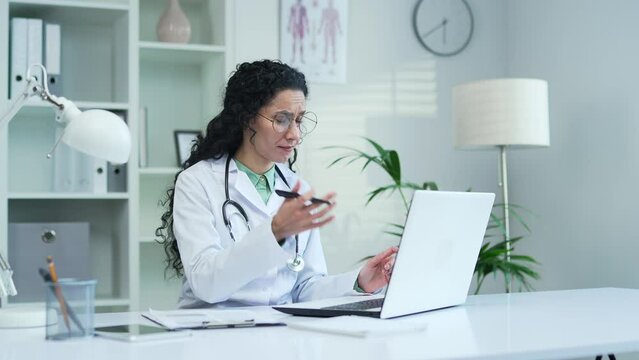 Frustrated female doctor complaining about laptop or software not working well while sitting in office at hospital clinic Medical worker physician is disappointed by bad service or internet connection