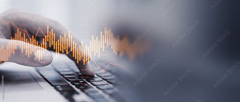 Poster close up of man hand using laptop keyboard with glowing downward business chart on blurry wide persp