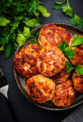 Homemade fried pork and beef meatballs in ceramic bowl, dark table background, top view