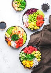 Poke bowl set: tuna, salmon, shrimps with avocado, fruits and vegetables, white rice and other ingredients. Hawaiian cuisine dish. White table background, top view