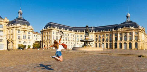 Happy woman jumping in Bourse square- Bordeaux city- France © M.studio