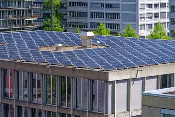 Aerial view of rooftops with solar panels at City of Zürich district Oerlikon on a blue cloudy...