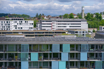 Fototapeta na wymiar Aerial view of rooftops with solar panels at City of Zürich district Oerlikon on a blue cloudy spring day. Photo taken May 12th, 2023, Zurich, Switzerland.
