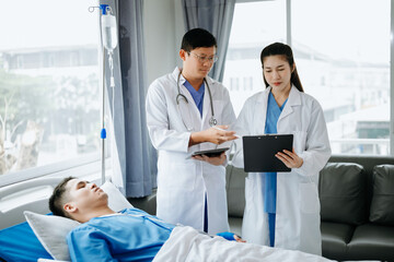 Obraz premium Two doctors talking to a patient lying in his bed with receiving saline solution in hospital .