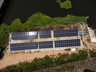 Top view on photovoltaic solar power panels. Drone aerial view of solar panels with water pumps, agricultural equipment for irrigation near rivers from clean energy or solar energy. 