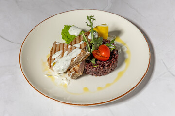Grilled meat served with black risotto