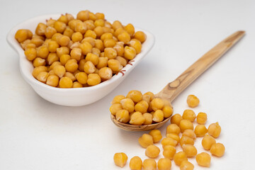 On the table Fresh boiled chickpeas on a plate and in a wooden spoon .