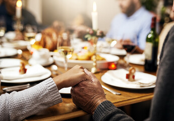 Closeup, thanksgiving and hand holding with family at table in dining room for holiday, food or...