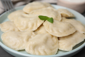 Fototapeta na wymiar Plate of delicious dumplings (varenyky) on table, closeup