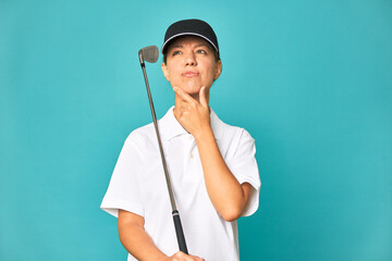 A young caucasian golfer woman looking sideways with doubtful and skeptical expression.