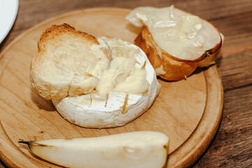 White baguette with olive oil and baked Camembert cheese on the table.