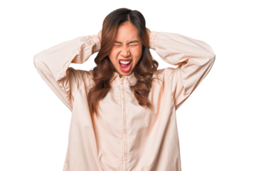 A young chinese woman covering ears with hands trying not to hear too loud sound.