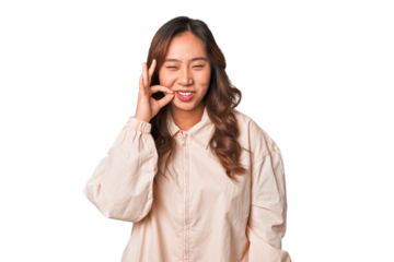 A young chinese woman with fingers on lips keeping a secret.